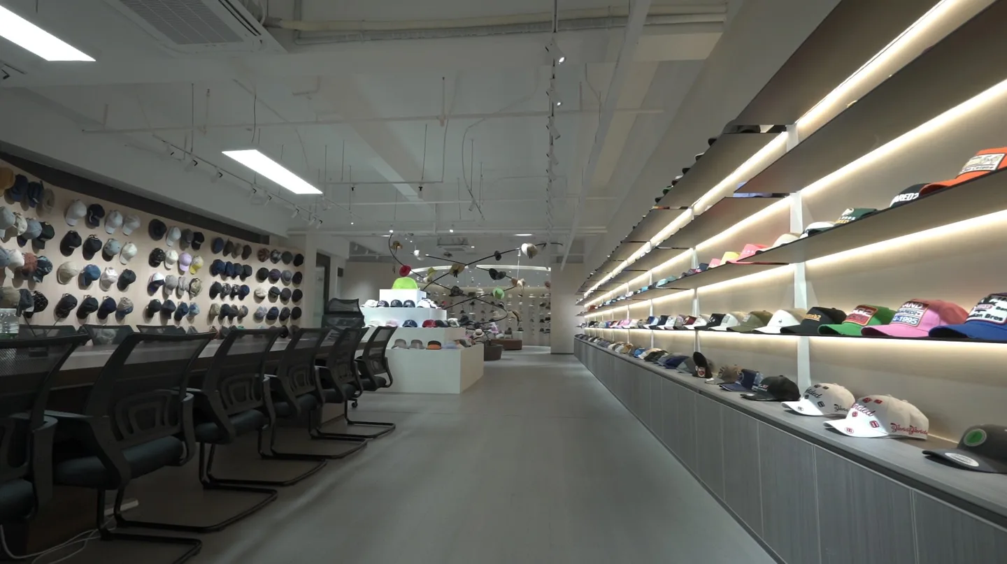 Showroom wall displaying finished cap samples and colorways
