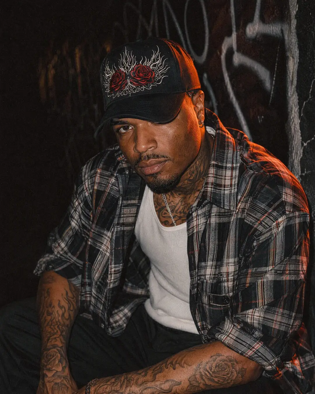 Fictional model wearing a curved-brim cap with original rose and flame embroidery.