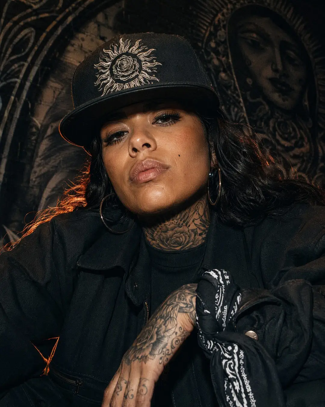 Fictional model wearing a flat-brim cap with original sun and rose embroidery.
